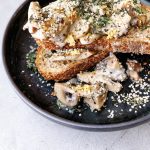 a closeup of delicious mushrooms on toast with fresh herbs