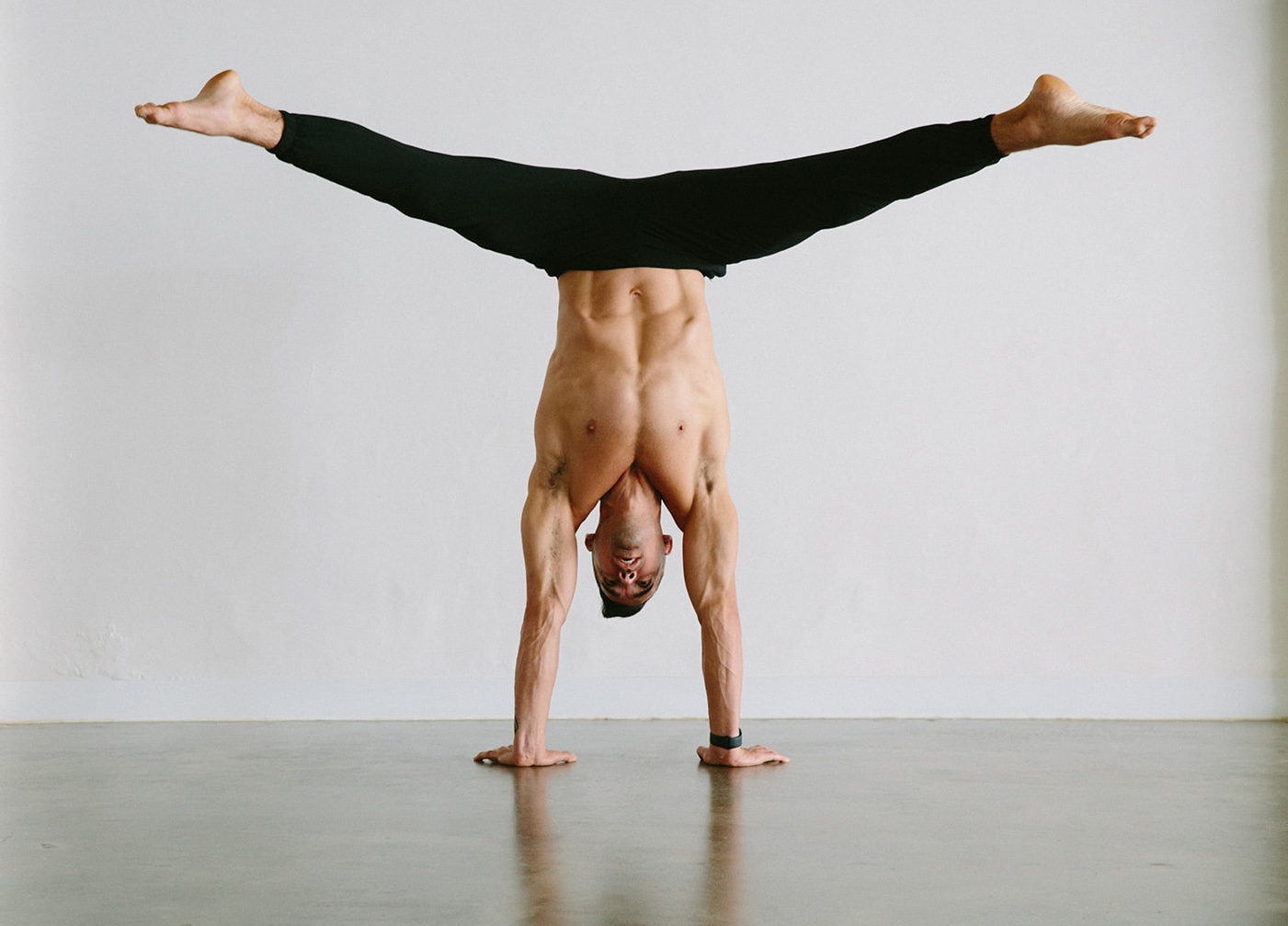 Yoga teacher Dustin Brown in a straddle handstand at warrior one yoga studio in Mordialloc