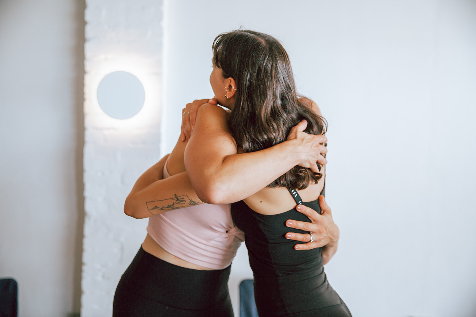 two women students hugging at warrior one yoga 200 hour vinyasa teacher training in mordialloc